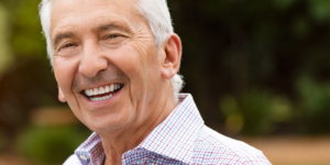 A man smiling confidently with the help of reconstructive dentistry.