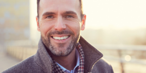 A man with a complete smile thanks to dental impants from Aspen Ridge Dental.