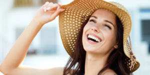 A young woman smiling while wearing a sunhat on vacation after teeth whitening in Casper.