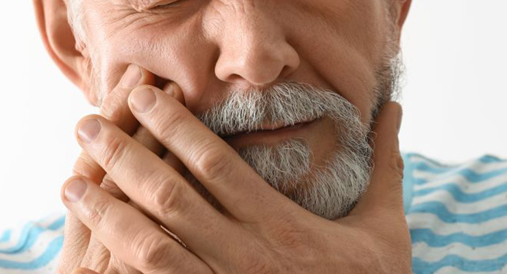 A man clutching his jaw in pain.